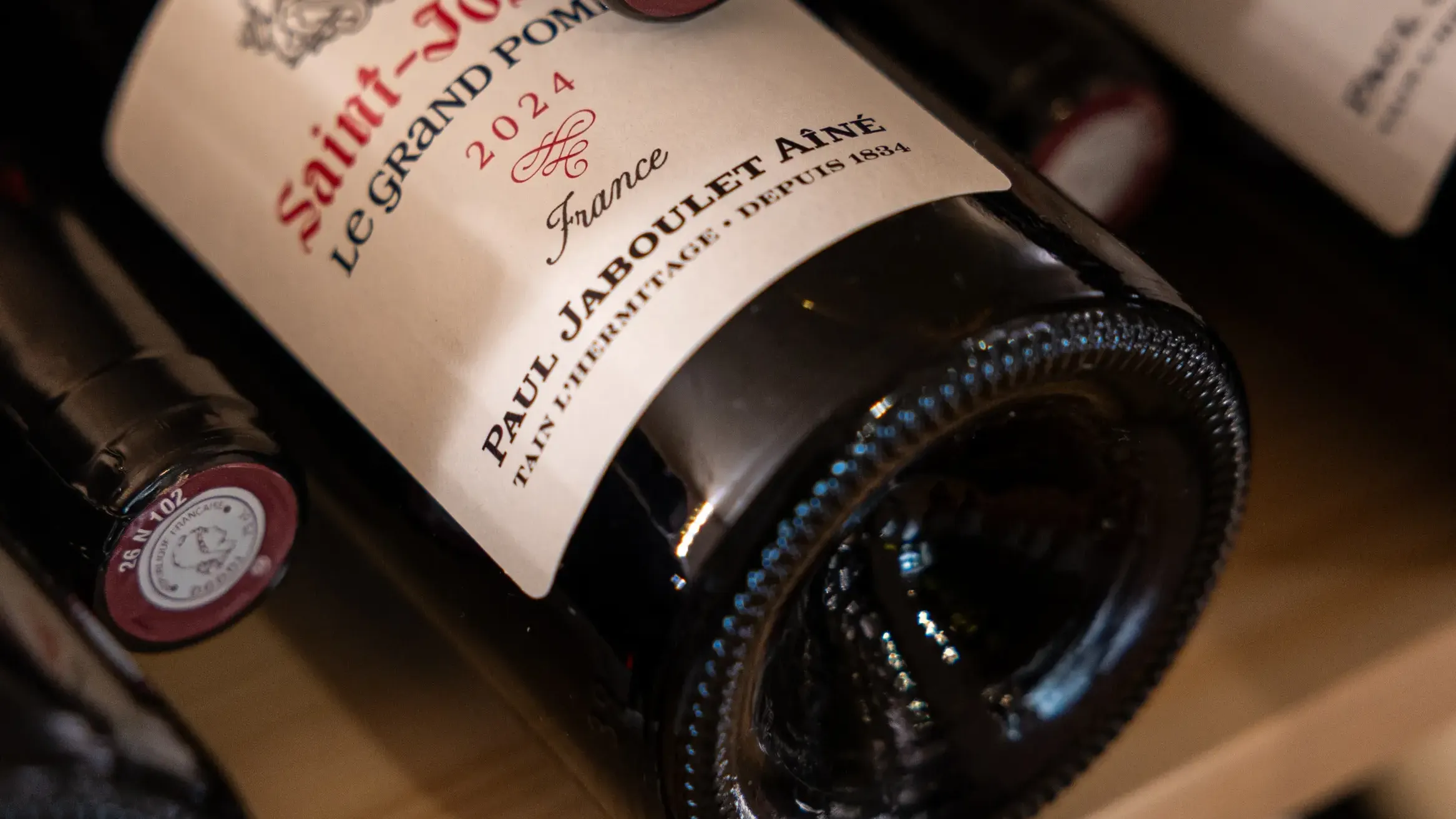 Bouteille de vin Saint-Joseph Le Grand Pommerat 2021 posée sur une étagère en bois